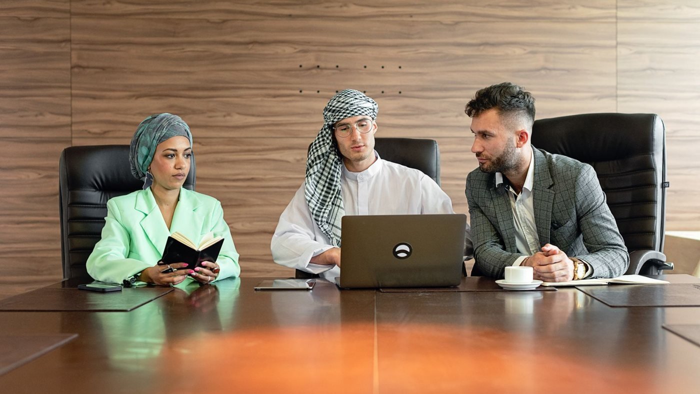 Small business team reviewing plans around a laptop during a work session.