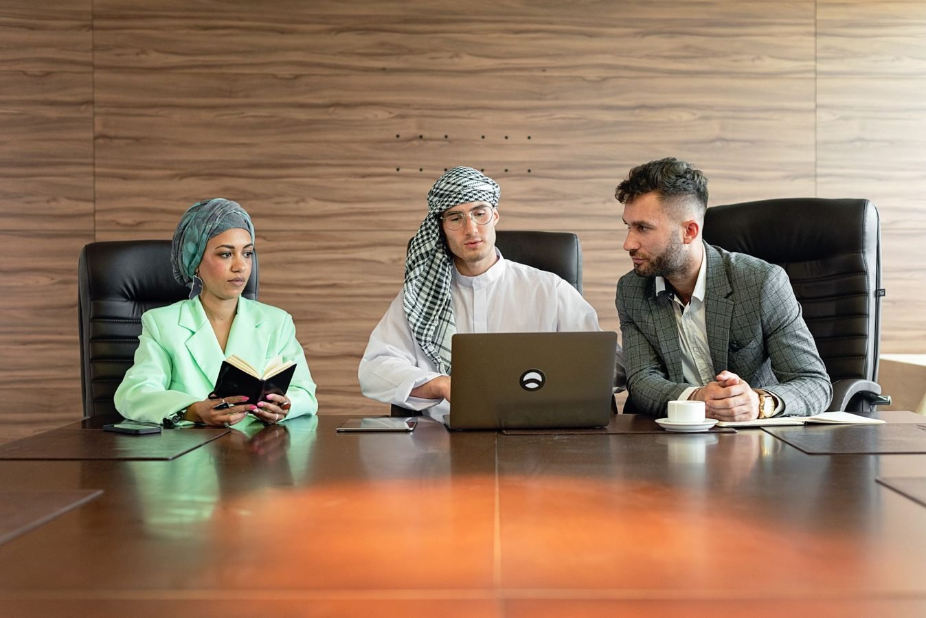 Small team reviewing laptop notes while planning a digital product offer.