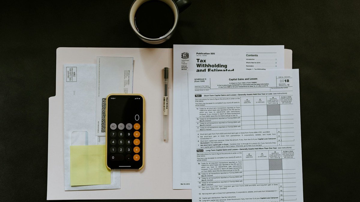 Small business owner reviewing expenses, invoices, and cash-flow notes at a desk.