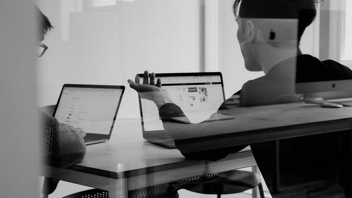 Business owner reviewing a project board and weekly priorities with a colleague.