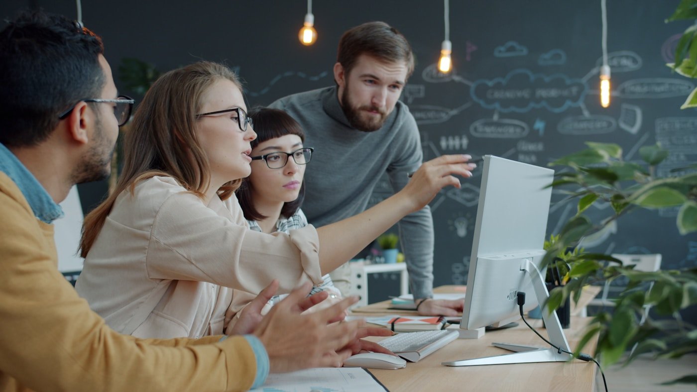 Small business team reviewing customer workflow and lead assignments together at a computer.